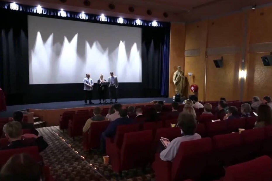 Three people on stage at a cinema